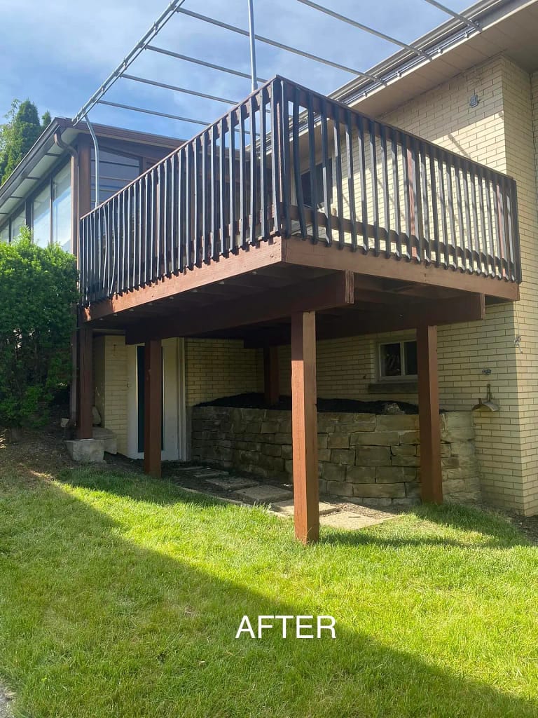 Restored wooden deck with dark railings on a modern house, set against a well-maintained lawn, freshly painted by a reputable residential painter in Pittsburgh PA, labeled "after.